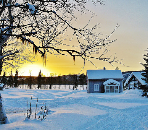 Vinterlandskap i norrland med ett hus med snö på taket